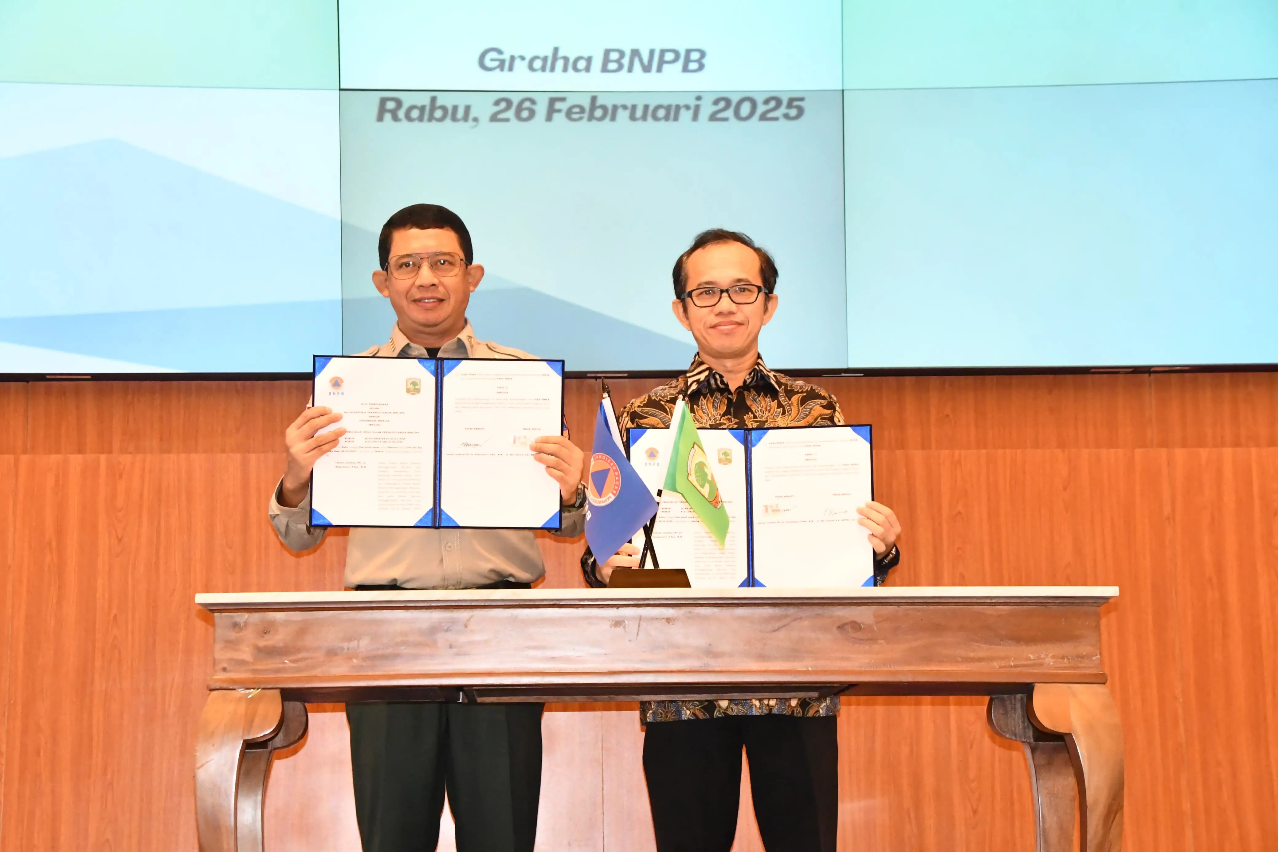 Kepala Badan Nasional Penanggulangan Bencana (BNPB) Letjen TNI Dr. Suharyanto, S. Sos., M.M. dan Rektor Universitas Andalas Dr. Efa Yonnedi, S.E., MPPM., A.kt., CA.CRGP. saat memperlihatkan dokumen nota kesepahaman di Graha BNPB, Jakarta pada Rabu (26/2).